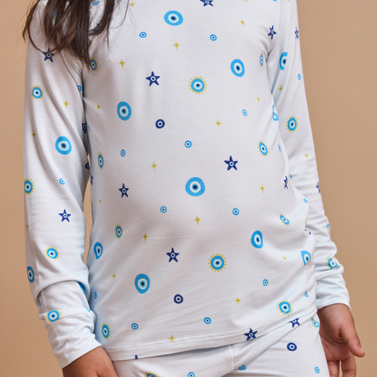 White long-sleeve shirt with blue and yellow star patterns on a beige background