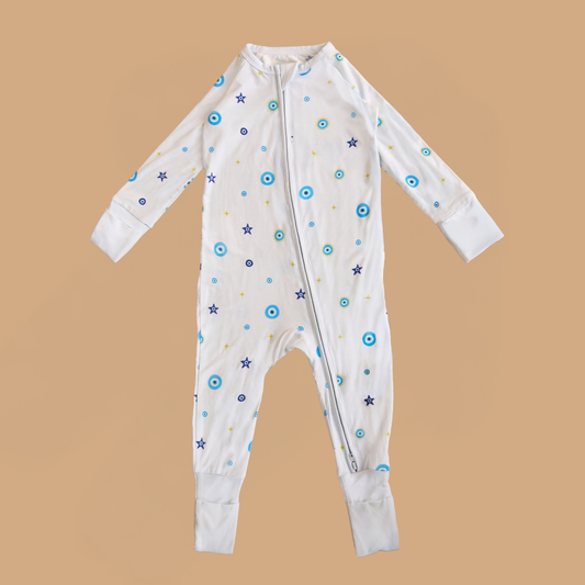 Baby onesie with star and circle patterns on a beige background