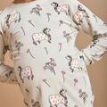 White shirt with cow and flower pattern on a beige background