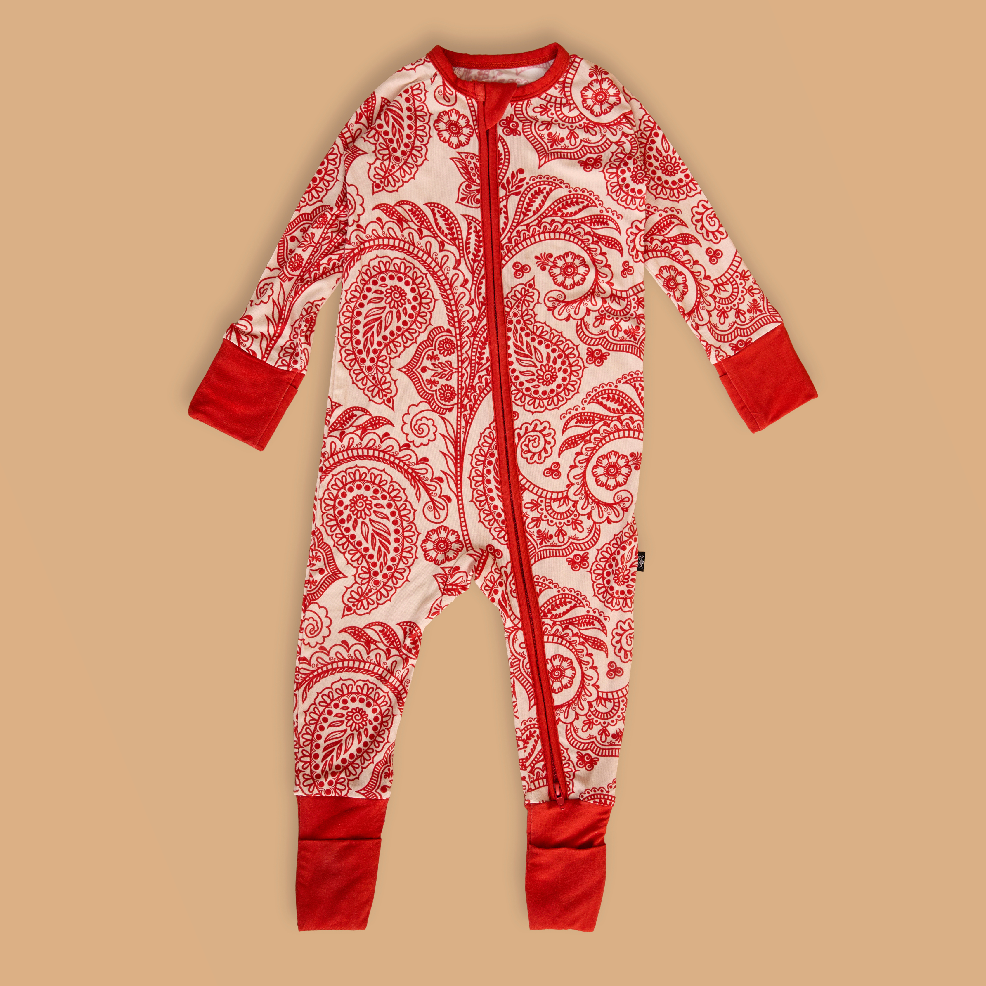 Mehendi Mosaic red and white patterned onesie on a beige background